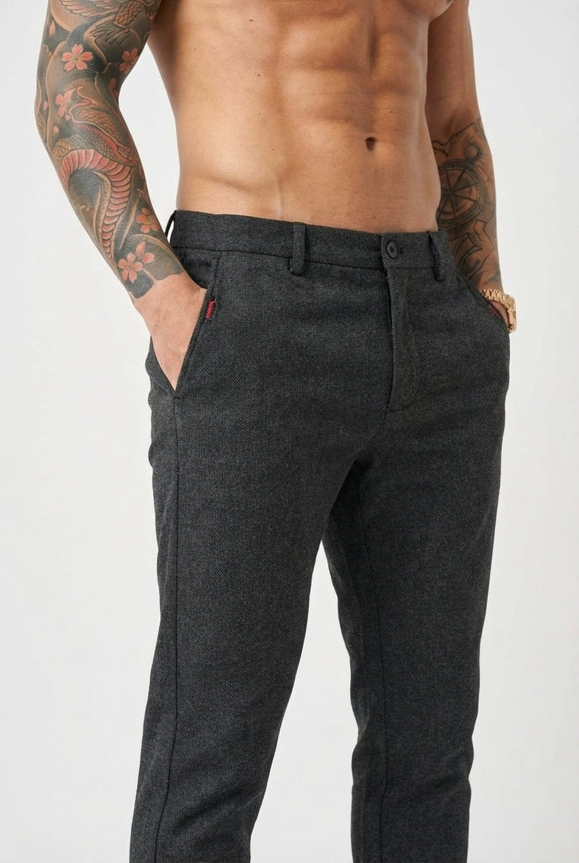 FJØRNA slim-fit black trousers displayed on a model, showcasing the tailored fit and sleek design of the pants.