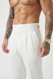 White tailored trousers by FJØRNA, featuring a sleek fit and classic design, shown on a model with a neutral background.