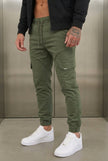 FJØRNA cargo jogger trousers in Army Green, featuring relaxed fit and multiple pockets, shown on a model.