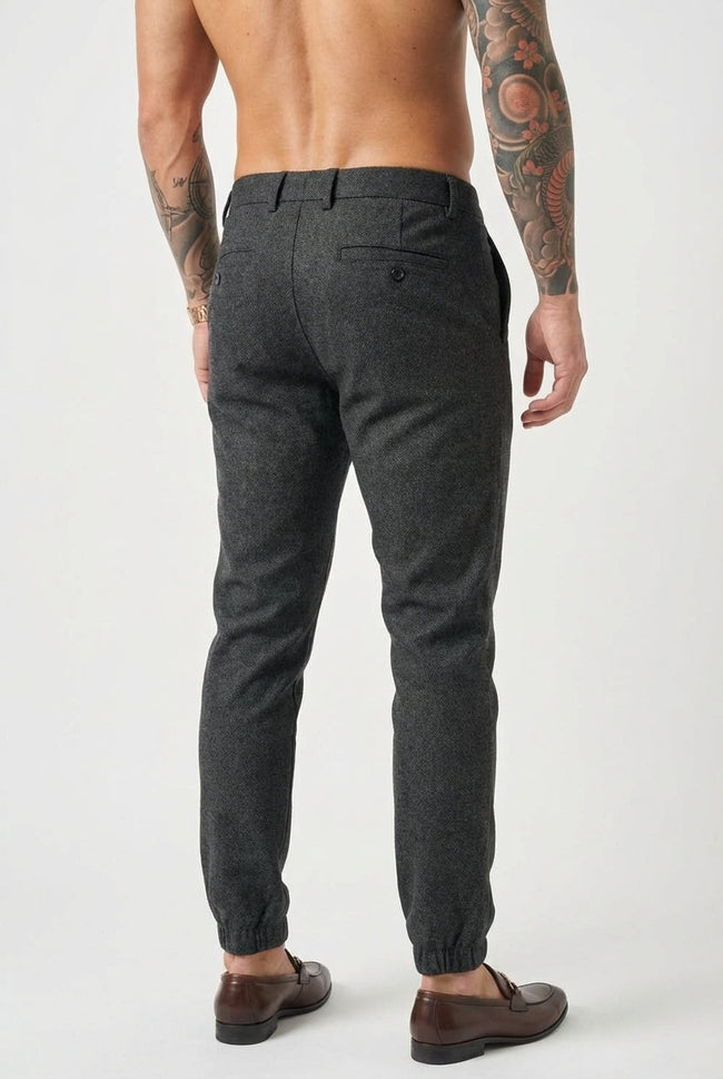 FJØRNA slim-fit black men's trousers displayed on a hanger with a clean, modern design and tailored fit.