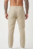 FJØRNA relaxed beige linen trousers displayed on a model, featuring a comfortable fit and casual style.