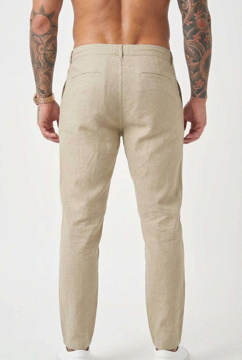 FJØRNA relaxed beige linen trousers displayed on a model, featuring a comfortable fit and casual style.