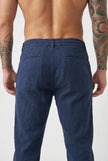 FJØRNA linen tailored trousers in a neutral color, shown on a model, with a focus on the fit and fabric texture.