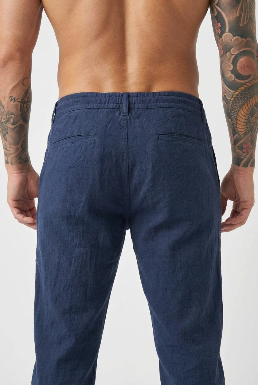 FJØRNA linen tailored trousers in a neutral color, shown on a model, with a focus on the fit and fabric texture.