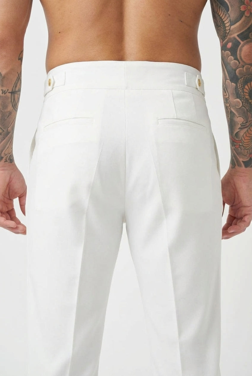 White tailored trousers by FJØRNA, featuring a sleek fit and classic design, shown on a model standing against a neutral background.