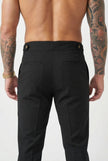 Black tailored trousers by FJØRNA, shown on a model, featuring a fitted waist and sleek, professional style.