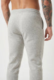 FJØRNA merino wool trousers in light grey, featuring a tailored fit and classic style, worn by a person in a casual setting.