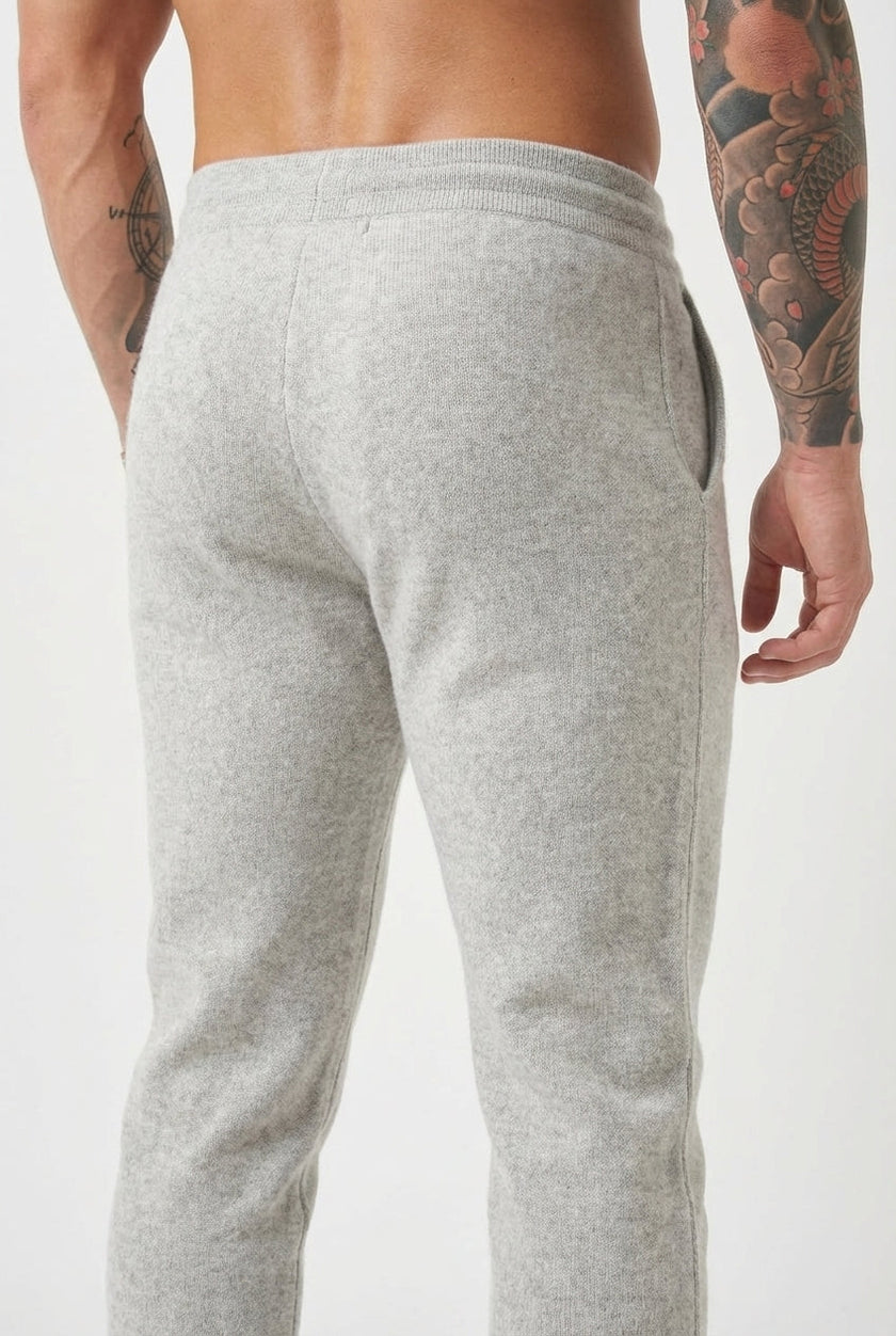 FJØRNA merino wool trousers in light grey, featuring a tailored fit and classic style, worn by a person in a casual setting.