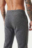 FJØRNA Merino Wool Trousers in dark grey, tailored fit with soft wool fabric, shown on a model.