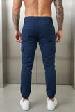 FJØRNA navy cargo jogger trousers displayed on a model, featuring multiple pockets and a relaxed fit.