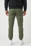 FJØRNA cargo jogger trousers in army green, featuring multiple pockets and a relaxed fit, shown on a model for casual wear.