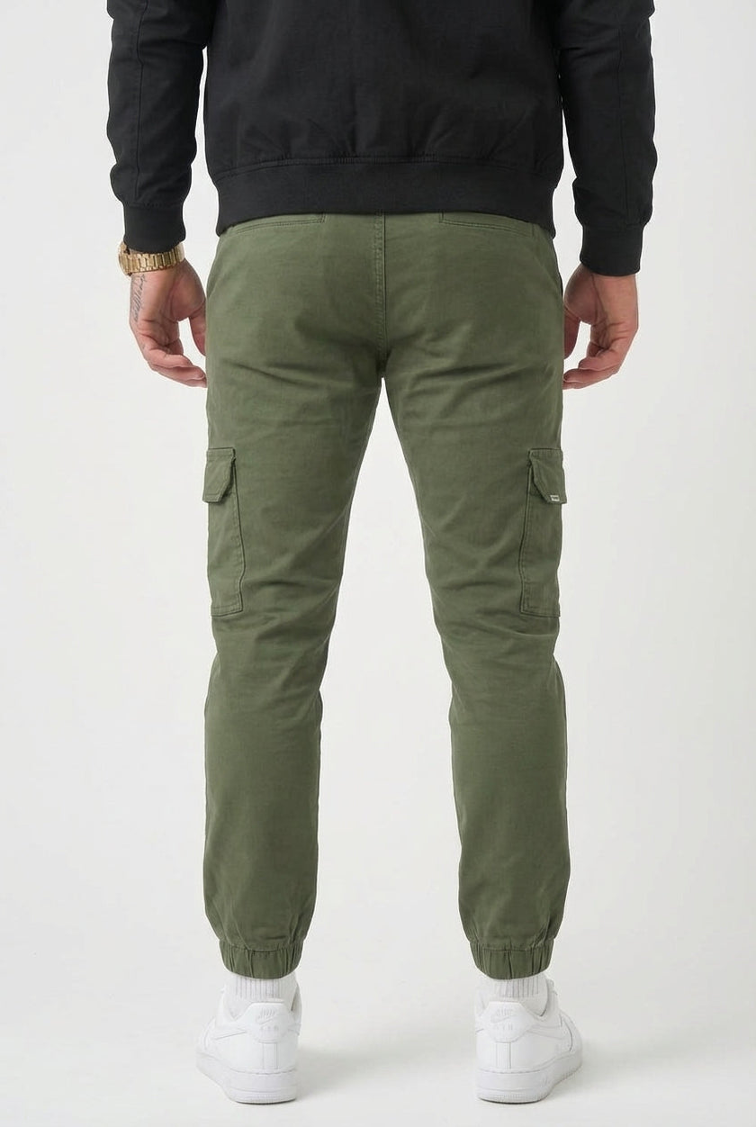 FJØRNA cargo jogger trousers in army green, featuring multiple pockets and a relaxed fit, shown on a model for casual wear.