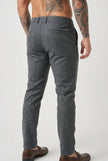 Slim-fit light grey trousers by FJØRNA, displayed on a model, showcasing the tailored fit and fabric texture.