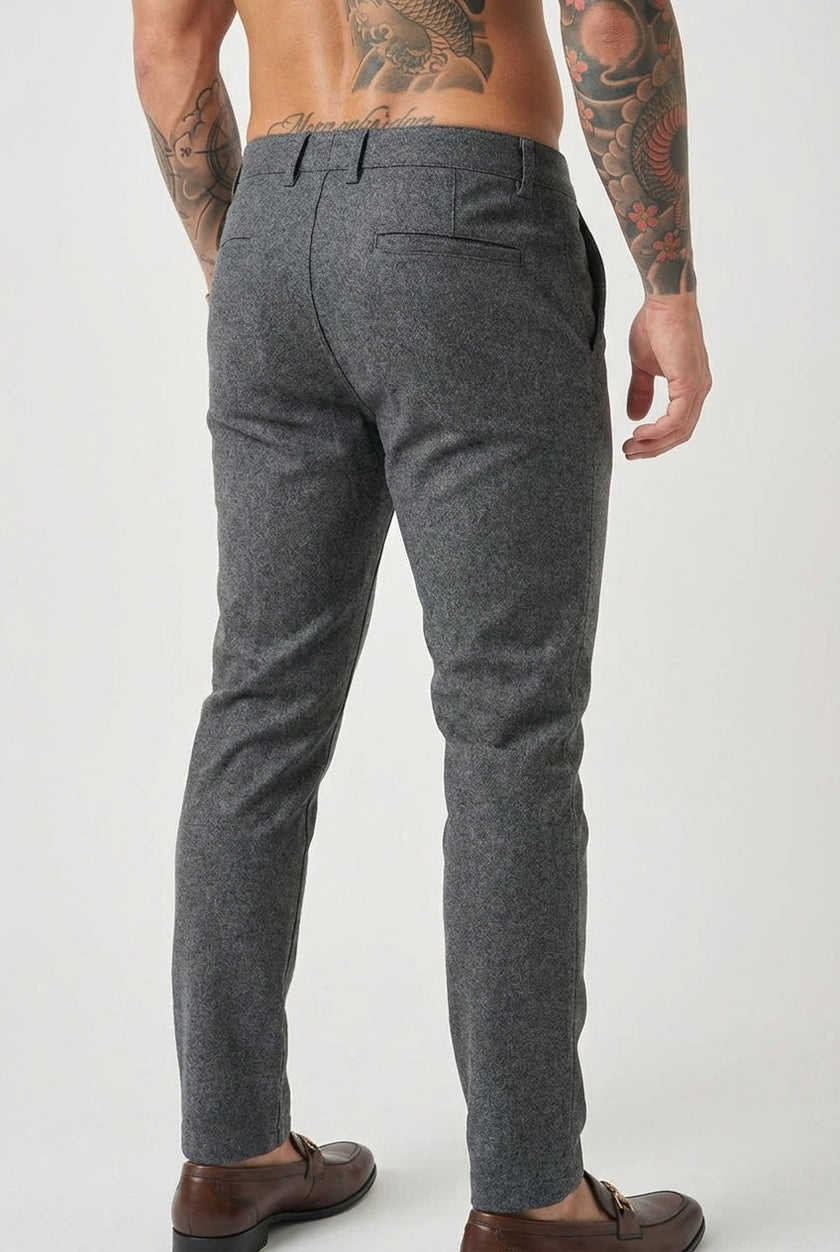 Slim-fit light grey trousers by FJØRNA, displayed on a model, showcasing the tailored fit and fabric texture.