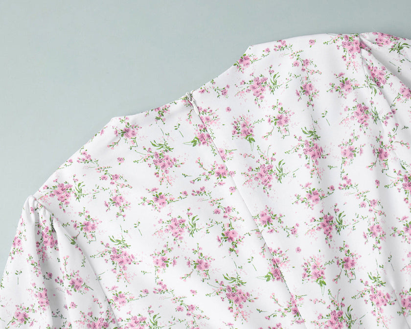 FJØRNA white V-neck floral mini dress with lantern sleeves, detailed close-up of fabric and design.