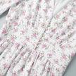 FJØRNA white floral V-neck mini dress with lantern sleeves, featuring a detailed view of the elegant floral pattern.