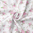 FJØRNA V-neck white floral mini dress with lantern sleeves, featuring a detailed close-up of the floral pattern and elegant design.