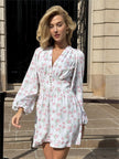 FJØRNA white floral V-neck mini dress with lantern sleeves, front view showcasing lightweight fabric and delicate floral pattern.