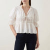 White women's summer blouse with V-neck, puff sleeves, and lace details by FJØRNA, perfect for warm-weather outfits.