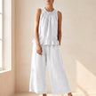 White two-piece women's co-ord set with ruffle high neck top and matching pants by FJØRNA. Elegant and stylish outfit.