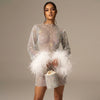 White FJØRNA sequin feather mini dress with long sleeves and sheer details, featuring sparkling sequins and feather accents.