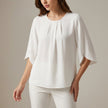 White pleated summer blouse for women by FJØRNA, casual top with a relaxed fit and lightweight fabric.