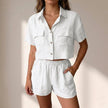 FJØRNA relaxed white two-piece shorts set with collared top and matching shorts in lightweight textured woven fabric.
