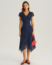 Navy blue polka dot chiffon midi dress with V-neck, tiered ruffles, and short sleeves, designed for women by FJØRNA.