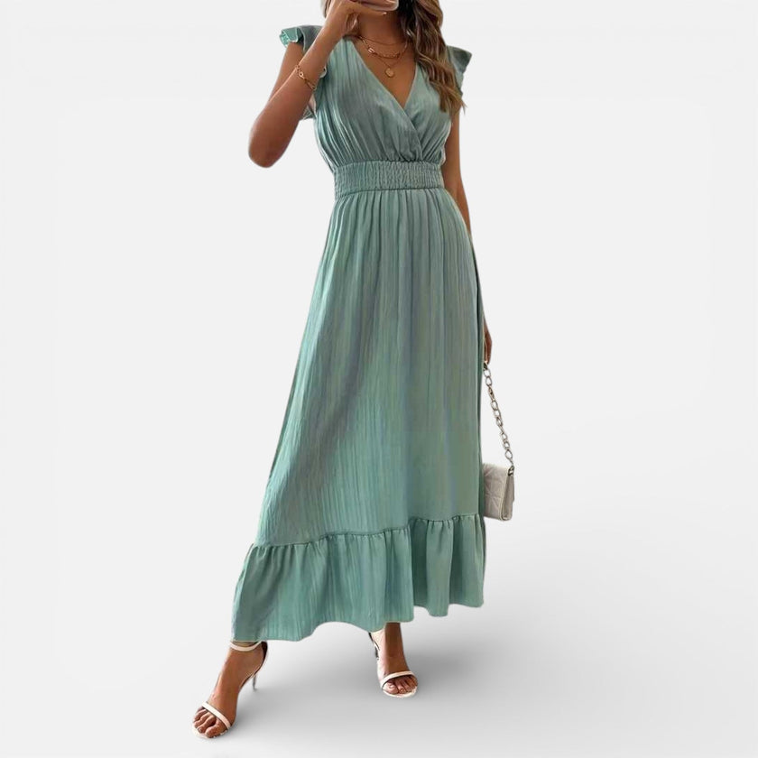 Women's sleeveless maxi dress by FJØRNA, flowy fit with a timeless style, shown in a natural, elegant pose.