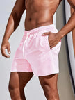 Men's striped FJØRNA swim shorts with a regular fit, featuring a vibrant summer design, perfect for beach and pool activities.
